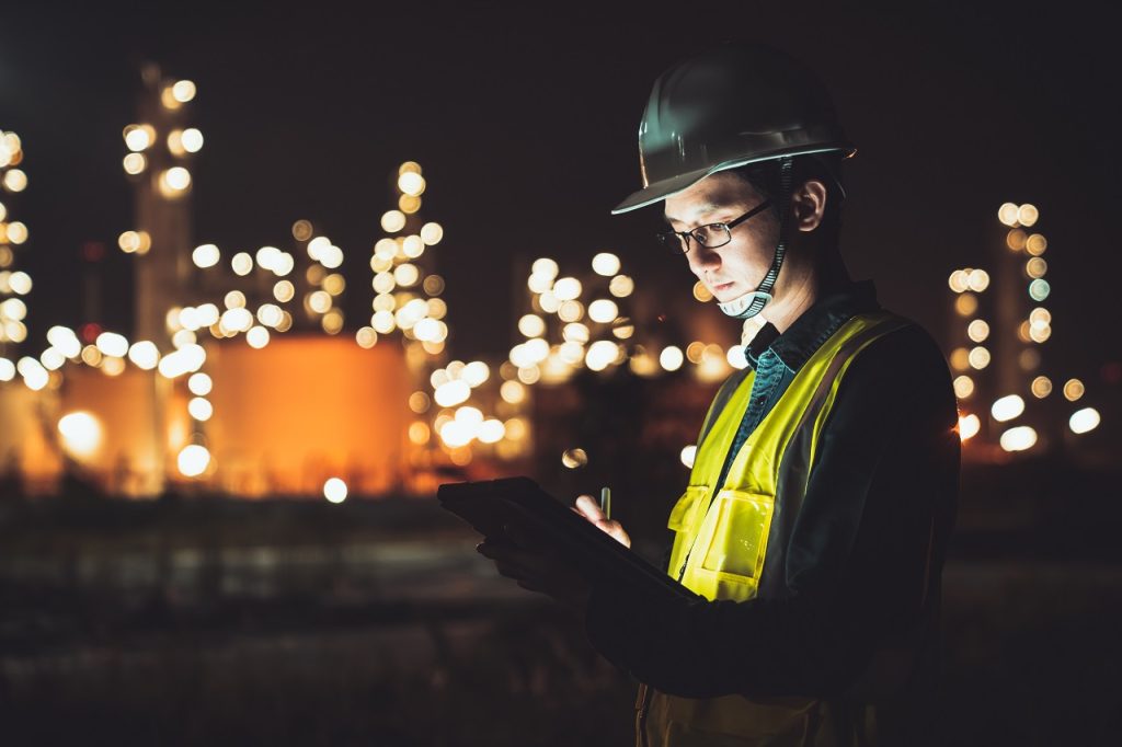 An asian factory worker on a tablet