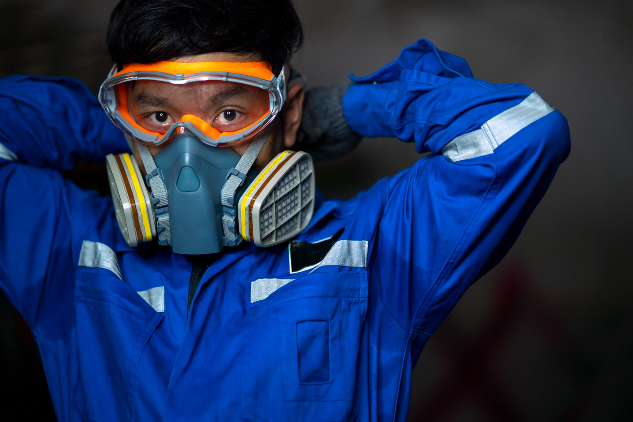 A worker in an industrial park wearing PPE
