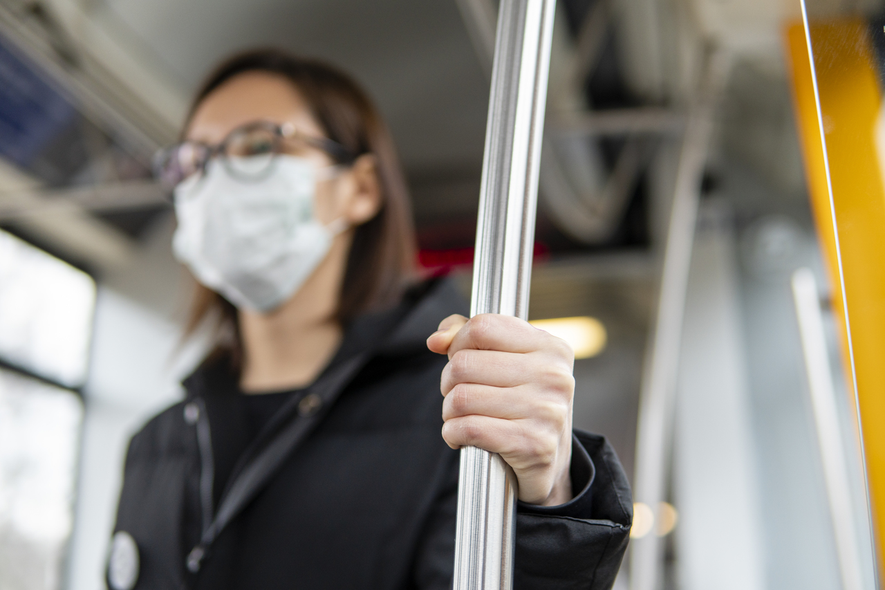 A woman in a face mask on a bus