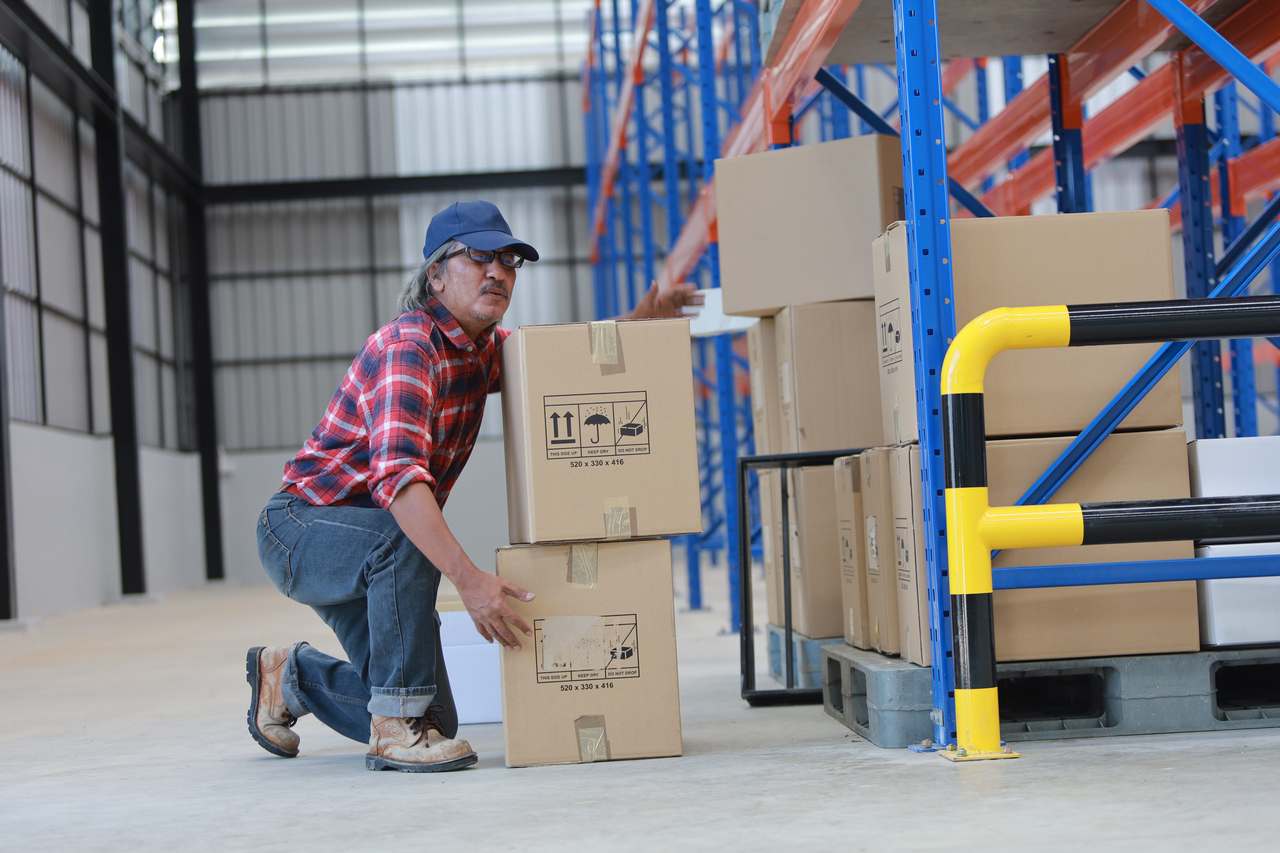 A factory worker with back pain due to lifting a box